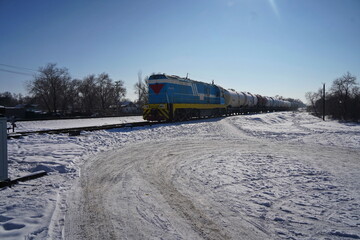 An electric locomotive with a freight train is traveling on rails.