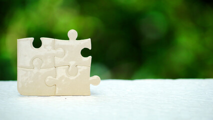 Concept puzzle pieces on natural bokeh background. Mission, success, solution, goal, cooperation,...