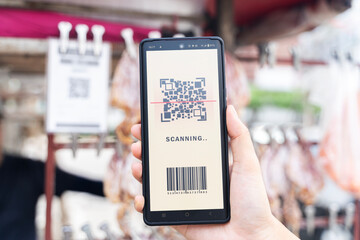 Female hand holding black mobile phone with qr code on the screen. scanning the qr code.