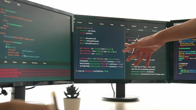 Slow motion back end software developer engineer for computer programming working together on debugging writing computing code, solving complex algorithms display on monitor in office. Burgeoning