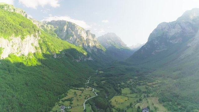 Shooting from a drone of high mountains and a beautiful valley at sunset