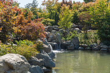 Krasnodar "Japanese Garden". Lake Oike with picturesque artificial waterfall. Artificial river flows along stone bed and flows into Lake Oike. Krasnodar Park or Galitsky Park.