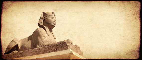 Grunge background with paper texture and sphinx statue. Horizontal banner with ancient egyptian...