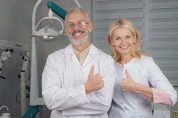 Male and female dental doctors wearing face sitting at his clinic.