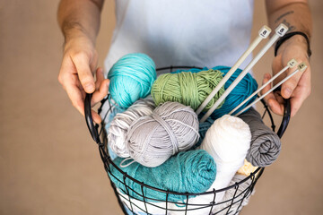 A man holds a large basket with colorful yarn.
