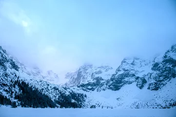 Papier Peint photo autocollant Tatras Winter dawn in mountains. Beautiful winter landscape with mountain lake and snowy hills. Morskie oko lake. Lake in tatra mountains in winter at dawn. Poland, Zakopane.