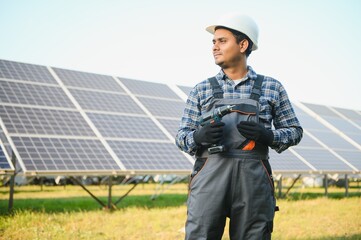 Male arabian engineer checking resistance in solar panels outdoors. Indian man working on station