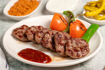 Grilled meat balls. With Tomatoes, Peppers, Appetizers and Special Sauce. Turkish meatballs on a plate. Close up