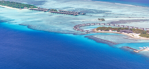 Maldives paradise island resort. Tropical aerial landscape, seascape yacht with water bungalows villas with amazing sea beach. Exotic tourism destination, summer vacation background. Aerial travel