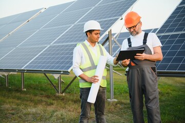Two male engineers Currently working on plans to install solar panels at renewable solar power...