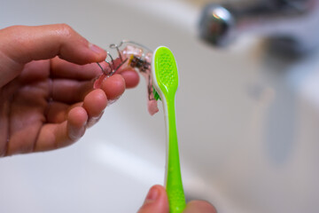 View of kid´s hands cleaning the orthodontic trainer, the chance of a beautiful smile. 