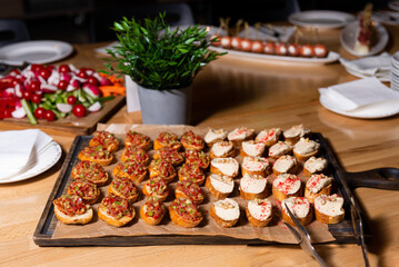 Assorted Bruschetta Platter on Wooden Board. An appetizing selection of bruschetta with various toppings on a rustic wooden board, ready for event catering.