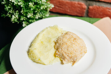 Obraz na płótnie Canvas Chicken Breast Cutlet with Mashed Potatoes on Plate. A simple yet appetizing meal of a juicy chicken breast cutlet served alongside creamy mashed potatoes on a white plate.