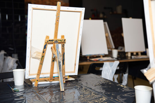 Art Studio with Easels and Blank Canvases. An art studio scene featuring easels with blank canvases, paint brushes, and a creative atmosphere ready for an art class.
