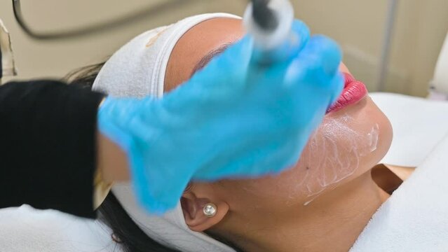 Using an RF electromagnetic device for radiofrequency skin tightening or contouring treatment. At a facial care, dermatologist or aesthetic clinic.