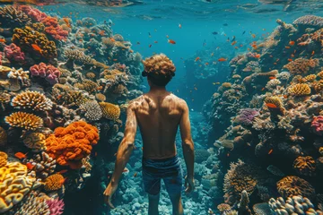 Gordijnen Caucasian man in a mask swims on a coral reef © sofiko14