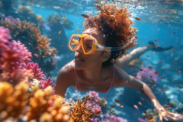 Fotobehang African girl in a mask swims on a coral reef © sofiko14