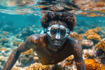 Foto op Canvas African man in a mask swims on a coral reef © sofiko14