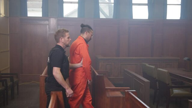 Police escorting inmate into court room trial