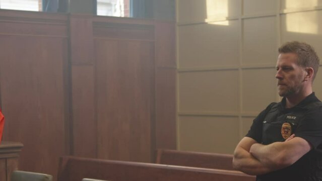 Pan from police to inmate in court room