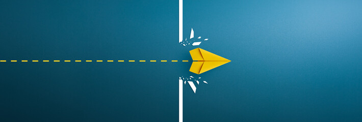 Yellow paper plane breaking through obstacle, Concept of overcoming barriers, goal, target. copy...