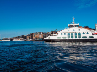 Modern ferry cruising in Oslo fjord and arriving to a city quayside