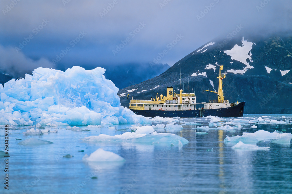 Sticker Ship at an iceberg at the coast at Svalbard