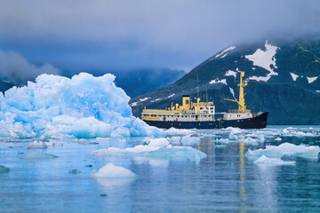 Ship at an iceberg at the coast at Svalbard