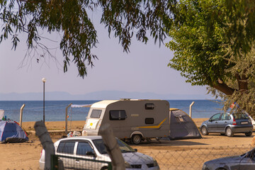 Trailer for a camping car on the seashore in an equipped camping place. Car for traveling. Trailer with a sleeping place.