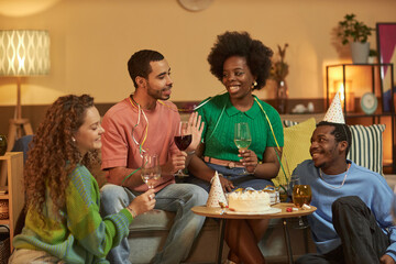 Multiethnic group of adult people enjoying Birthday celebration during cozy home gathering