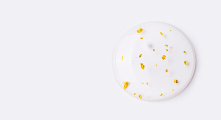 serum gel essence texture with gold closeup on a light background