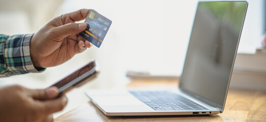 Close Up man hands holding credit card using online shopping with laptop, Online payment at home or...