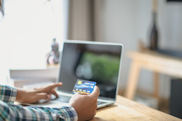 Close Up man hands holding credit card using online shopping with laptop, Online payment at home or office, internet banking, future lifestyle ideas for spending or entrepreneurs in ordering products