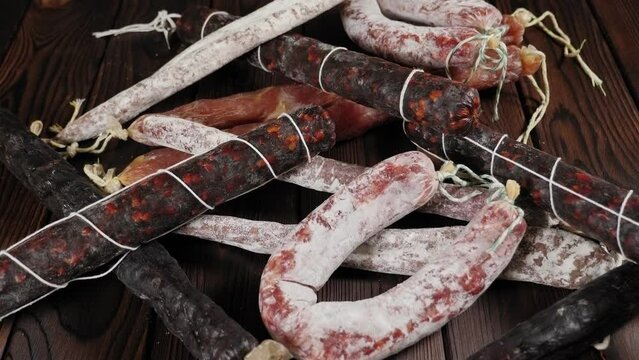 Close-up of set of different dry sausages on a wooden background. Spanish salami. 