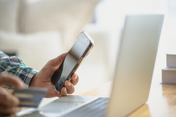 Close Up man hands holding credit card using online shopping with laptop, Online payment at home or office, internet banking, future lifestyle ideas for spending or entrepreneurs in ordering products