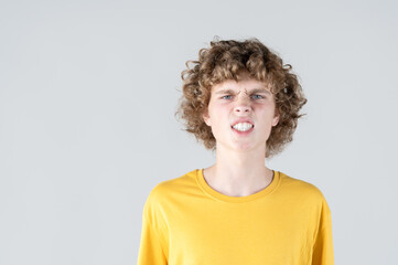 Portrait of curly-haired man with contorted face, baring his teeth in comical and exaggerated...