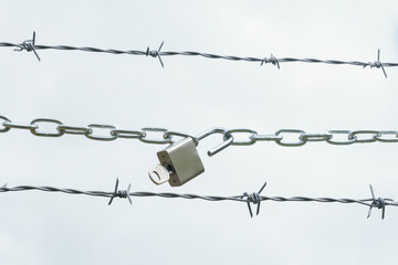 chain with open padlock on a barbed wire isolated on a white background ,freedom concept