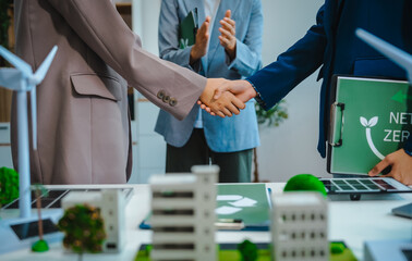 Sustainable business meetings at desks, green energy concepts. People in business suits discussing eco-friendly solutions, solar cells, wind turbines, and promoting net-zero practices.