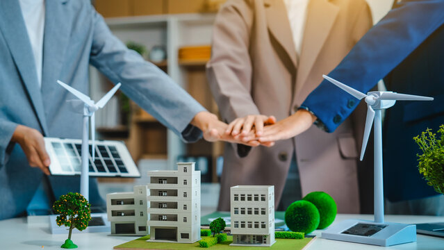 Sustainable business meetings at desks, green energy concepts. People in business suits discussing eco-friendly solutions, solar cells, wind turbines, and promoting net-zero practices.