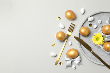 Golden eggs on table with fork and knife