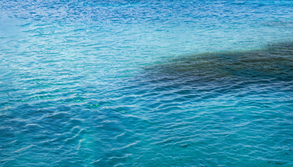 Ocean sea texture with calm clear water of lagoon near shore of tropical island
