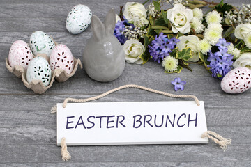 The text Easter Brunch written on a sign with Easter eggs and flowers.
