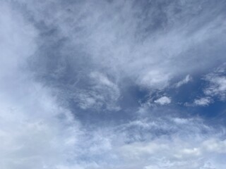 Obraz premium A Mesmerizing Display of Nature Artistry with White Clouds Painting Patterns on a Blue Canvas