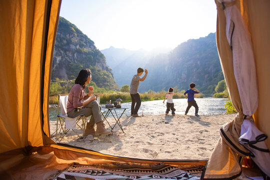 Happy young family camping outdoors