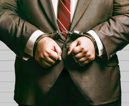 Corrupt businessman handcuffed by police following a criminal investigation. Digital art.