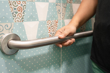 Asian elderly woman use toilet bathroom handle security, healthy strong medical concept.