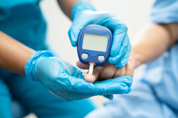 Doctor check diabetes from finger blood sugar level with finger lancet.