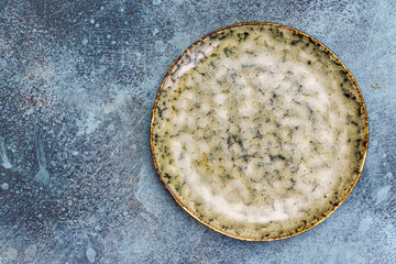 Green and beige spotted plate on a grunge background above