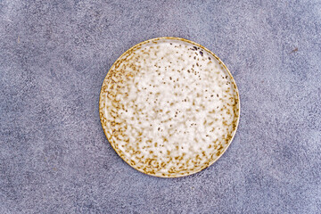 White and brown spotted plate on a gray background above - 750437951