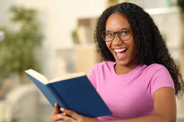 Happy black reader with eyeglasses looks at you